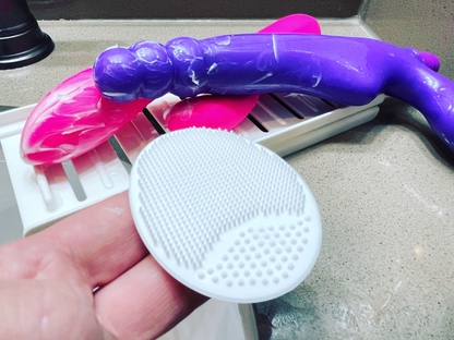The New Joybuff - Silicone Scrubber - Cleans off Sticky Stuff.  2 Vibrators covered in Cream on a Playtray 